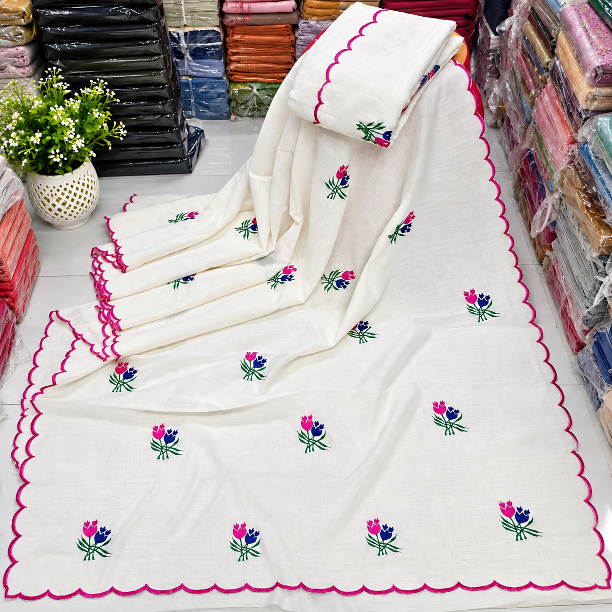 Exclusive off-white cotton embroidered saree with scalloped borders.